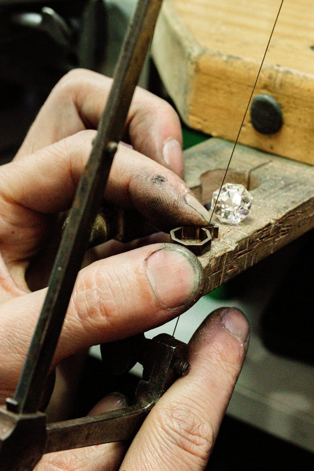 A jeweler's saw cutting an octagonal setting beside the loose stone it will hold
